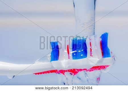View of colorful tooth brush under water fall.