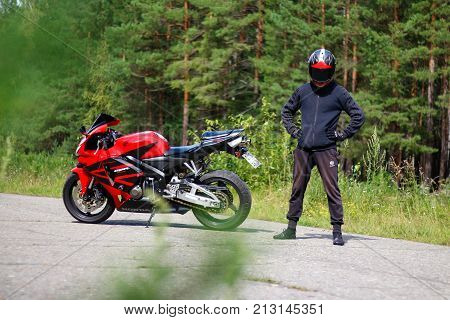 Krasnoyarsk, Russia - August 09, 2017: A Motorcyclist Wearing A Helmet With A Black Visor And Red Sp