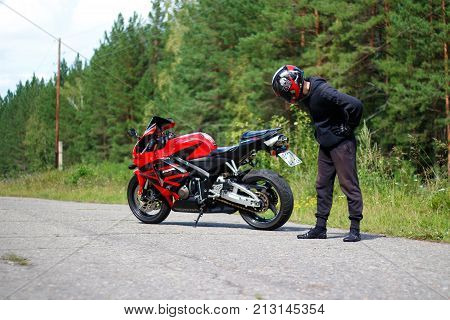 Krasnoyarsk, Russia - August 09, 2017: A Motorcyclist Wearing A Helmet With A Black Visor And Red Sp