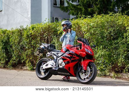 Krasnoyarsk, Russia - August 09, 2017: A Girl Motorcyclist Wearing A Helmet And Red Sport Bike Honda