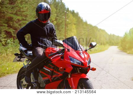 Krasnoyarsk, Russia - August 09, 2017: A Motorcyclist Wearing A Helmet With A Black Visor And Red Sp
