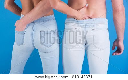 Gentle married couple in jeans rear view. Lovers man and woman hugging each other. Male and female buttocks in blue pants. Family dress code for walk clothes for home. Naked sexy couple