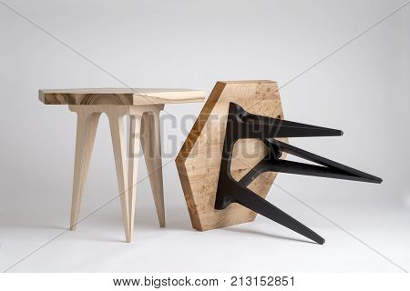 Two Modern Wooden Coffee Tables, One Tilted With Black Legs