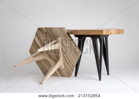 Two Modern Wooden Coffee Tables, One Tilted With Unpainted Legs