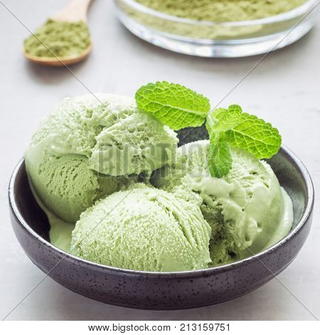 Matcha green tea ice cream balls in black bowl square format