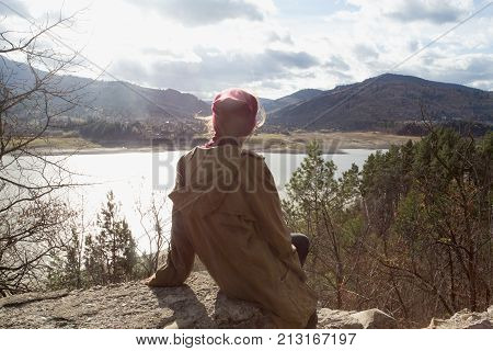 Girl Hipster Sits On The Background Of Mountains