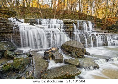 Brush Creek Falls a waterfall in Jennings County Indiana is topped by autumn foliage aglow in the light of late afternoon.