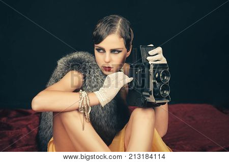 Woman With Retro Hair, Makeup And Old Camera.