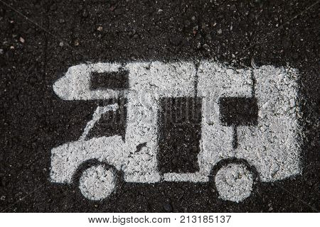 white motor home is painted on the asphalt on a parking spot for caravans