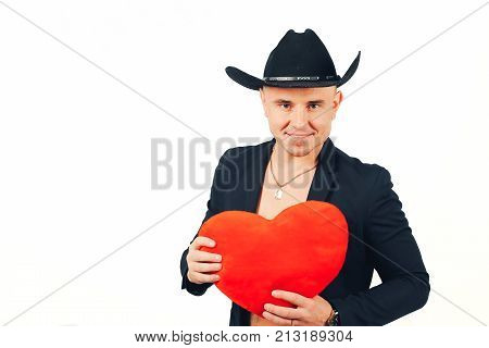 A man is a womanizer. Man of ladies. Man of womanizer in a black suit and hat with a heart in hands on a white background.