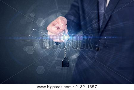 Businessman in suit holding over a key with connection concept around