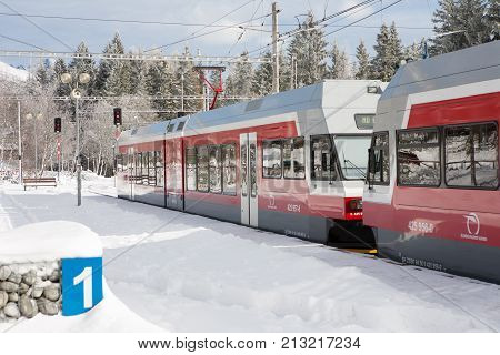 STRBSKE PLESO SLOVAKIA - NOVEMBER 1 2017: Electric train waiting for passangers in snowy railway station of Strbske Pleso in Slovakia