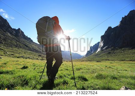 woman with backpack hiking in mountains travel lifestyle success concept adventure active vacations outdoor mountaineering sport sunrise landscape