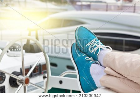 A pair of human legs in pants and bright blue topsiders on yacht background. Yachting
