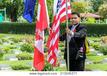 Labuan,Malaysia-Nov 12,2017:Man holds the Canada,Australia,Great Britain,India & New Zealand flag during the Remembrance Day at Labuan War Memorial park in Labuan,Malaysia.This event is held every year in November in remembrance of the unsung heroes.