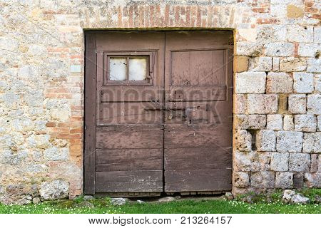An Ancient Wooden Door With Chain And Padlock