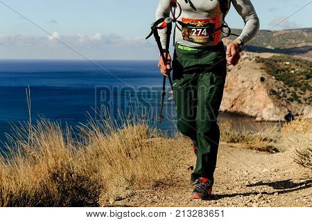 Crimea Russia - October 11 2017: male athlete runner with trekking poles runnning marine trail during Crimea Х Run