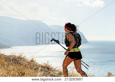 Crimea Russia - October 11 2017: girl runner with trekking poles runnning mountain sea trail during Crimea Х Run