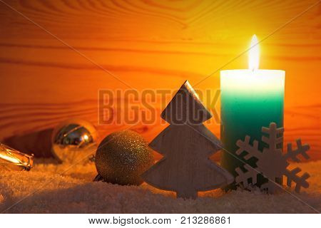 Avent candle and christmas decoration isolated on wood background. Christmas background with snow, candle and wood fir tree.