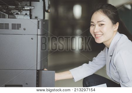 asian working woman hand putting a sheet of paper into a copying device