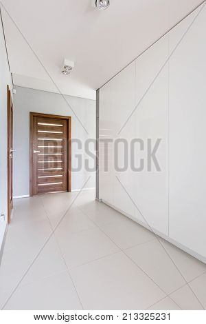 White Hallway With Wooden Door