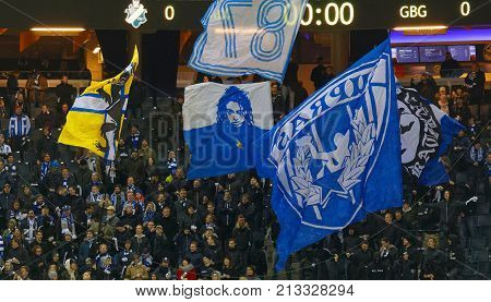 SOLNA SWEDEN - OCT 30 2017: The supporters to the soccer team IFK Gothrnburg waring blue and white scarfs and waving flags. October 30 2017SolnaSweden