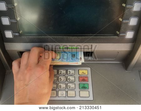 ATHENS GREECE - AUGUST 5 2017: Depositor withdraws 420 euro from ATM cash money machine the maximum amount allowed per week by capital controls imposed on banks and accounts. Greek financial crisis.