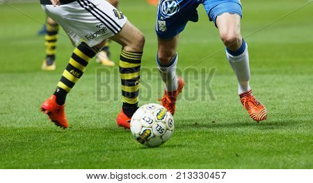 SOLNA SWEDEN - OCT 30 2017: Closeup of legs of soccer players fighting to get the ball in the game AIK and IFK Gothenburg. October 30 2017SolnaSweden