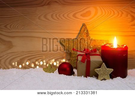 Avent candle and christmas decoration isolated on wood background. Christmas background with snow, candle and gift box.