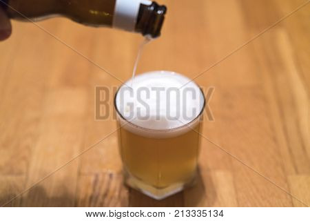 Pouring Beer In A Glass On A Wooden Table, Copy Space