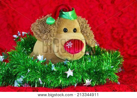 New Year Toy Dog Surrounded By Decorative Christmas Elements And Fir Branches On Red Background