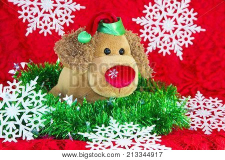 New Year Toy Dog Surrounded By Decorative Christmas Elements And Fir Branches On Red Background