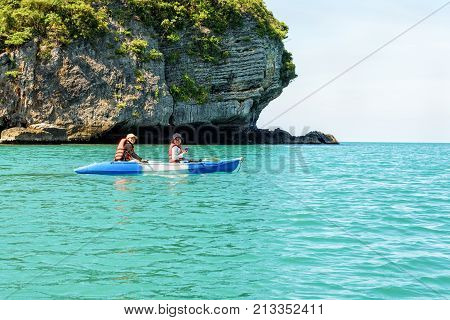 Two women are mother and daughter using a camera take pictures on kayak while travel by boat with happy on the sea during summer at Ko Wua Ta lap islands