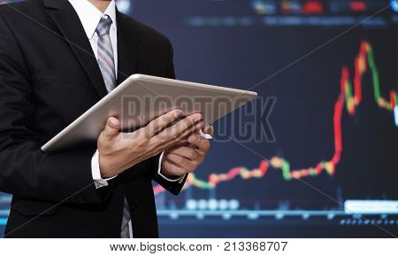 Businessman working on digital tablet with raising financial, stock exchange graph background. Investment in stock exchange and forex trading