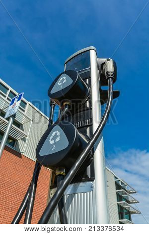 Charging station for zero emission cars on cloudy sky background. Electrical infrastructure for green sustainable future of the planet. EV - electric vehicle charging station. Electric charging point