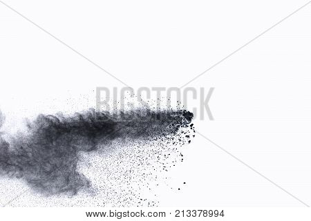 Black powder explosion. The particles of charcoal splatter on white background. Closeup of black dust particles splash isolated on  background.