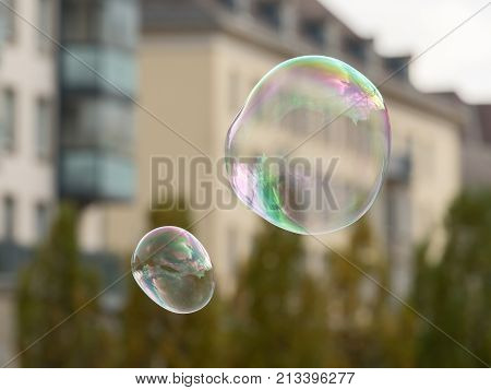 Soap Bubbles In Front Of An Old House And Trees
