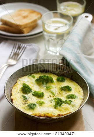 Omelette with broccoli and cheese served with bread toasts and lemonade. Selective focus.