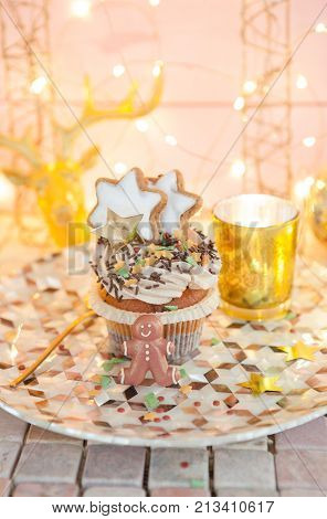 Little christmas cupcake with sugar decorations and cream frosting