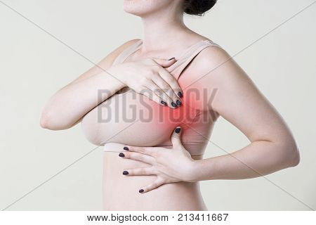 Breast test woman examining her breasts for cancer heart attack pain in human body on beige background