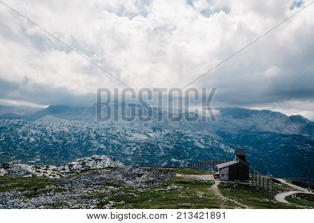 Scenic view of alps mountains a sunny day with church on foreground. Hoher Dachstein mountains.