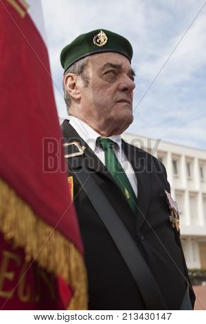 Aubagne, France. May 11, 2012. Portrait of a veteran of the French foreign legion in a green beret with the banner of veterans of the foreign legion during the annual meeting of veterans.