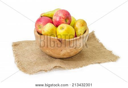 European pears Bosc red and yellow apples in rustic wooden fruit bowl on a sackcloth on a white background
