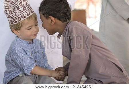 Nizwa Oman 10th Nobember 2017: omani kid and european kid giving eachother an eskimo kiss