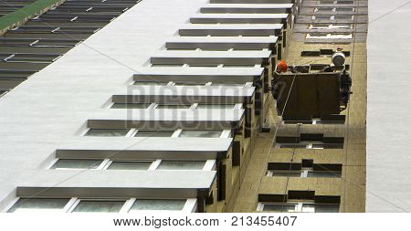 basket of fasade installers suspended on the wall of a multi storey building