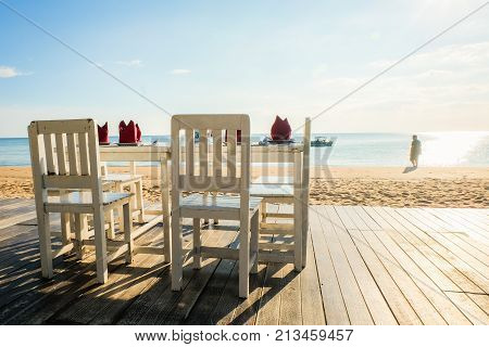 Chanthaburi Thailand - November 18 2016 : Many white wooden chairs with table set on the wooden floor at Chaolao Tosang beach for background or texture.
