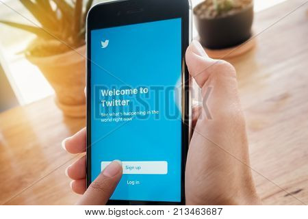 CHIANGMAI THAILAND -Feb 132017:man hand holding Iphone 6s touch sign up bottom for open Twitter app.Twitter is an online social networking and microblogging service that enables users to send and read 