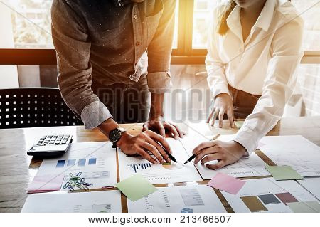 Young Businessmen And Partnership Holding A Pen Pointing The Graph To Analyze The Marketing Plan Wit