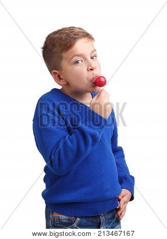 A boy in a blue sweater modestly licks a lolli pop unfolded half-turn on a white isolated background