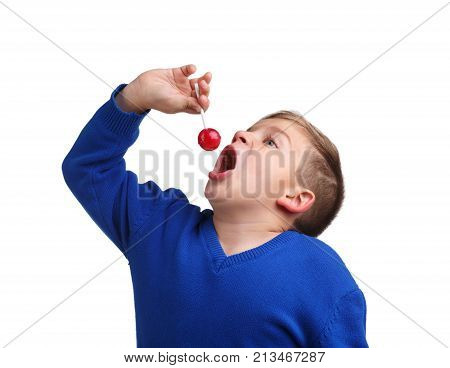 A boy in a blue sweater on top of a mouth thrusts a lollipop on a white isolated background